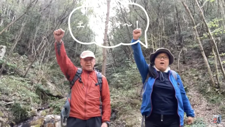 森の中で声を上げる登山の参加者