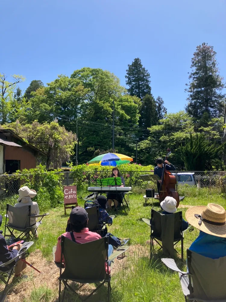里山の屋外で音楽を楽しむ人たち
